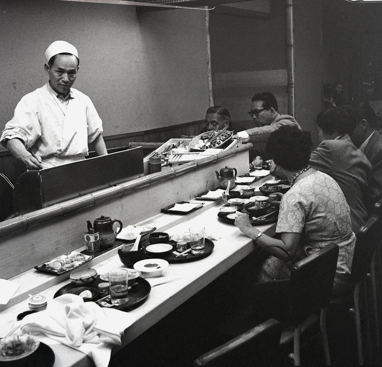 #51 People having a meal sitting on barstools at a counter at a restaurant in Tokyo, 1950s.