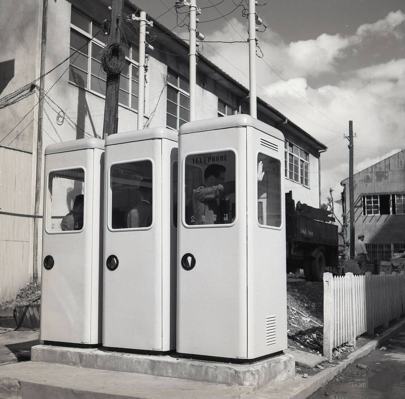 #65 A row of three newly installed public payphones, 1950s.