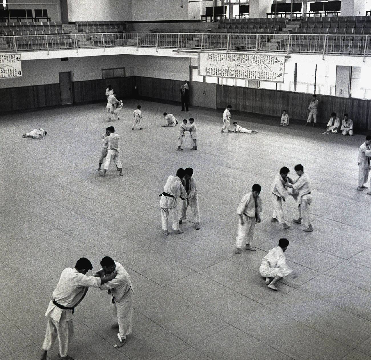 #73 Japanese men doing judo training inside a large sports hall, 1950s.