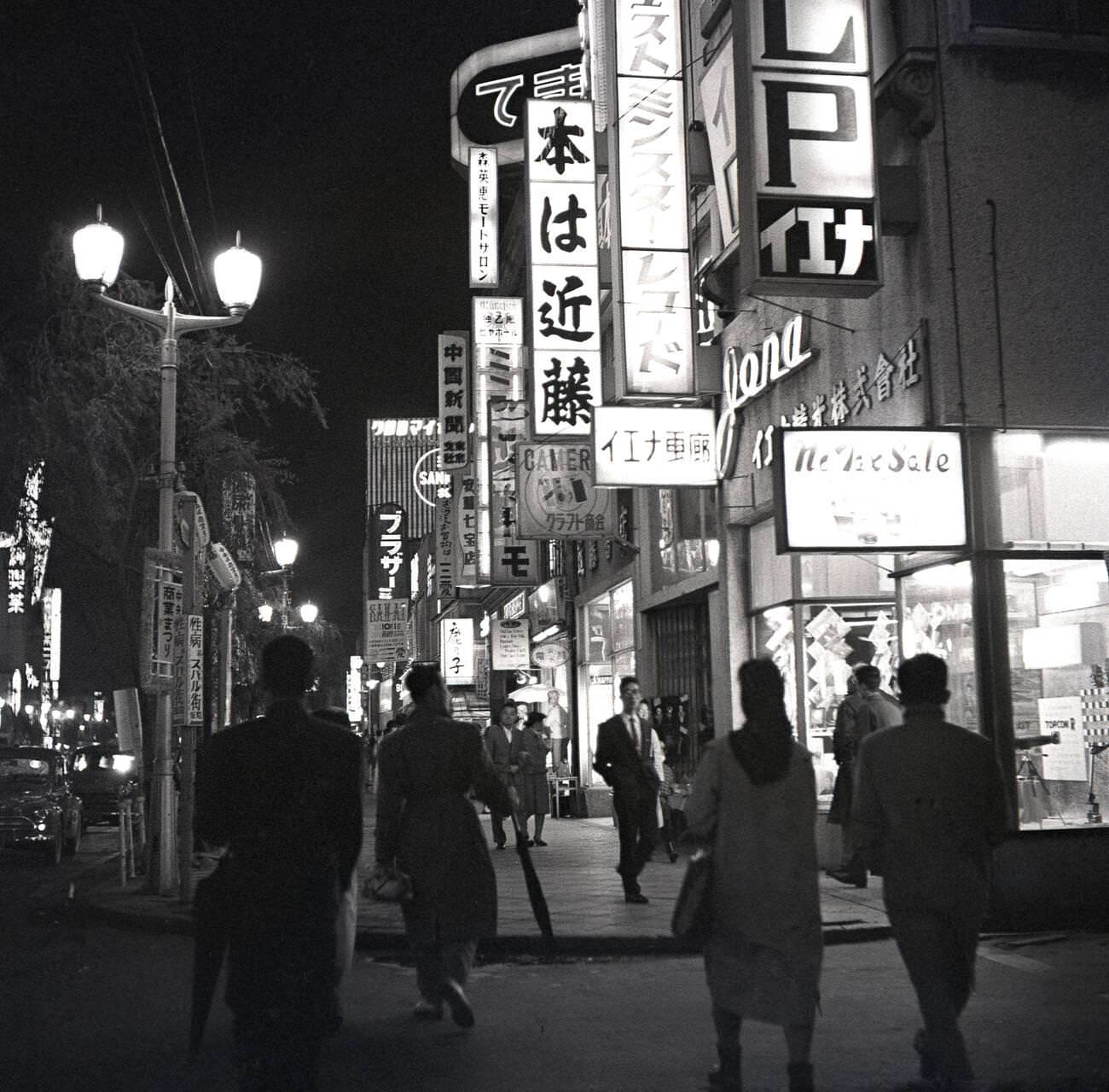 #74 Shop lights and signs light up the city of Tokyo at evening time, 1950s.