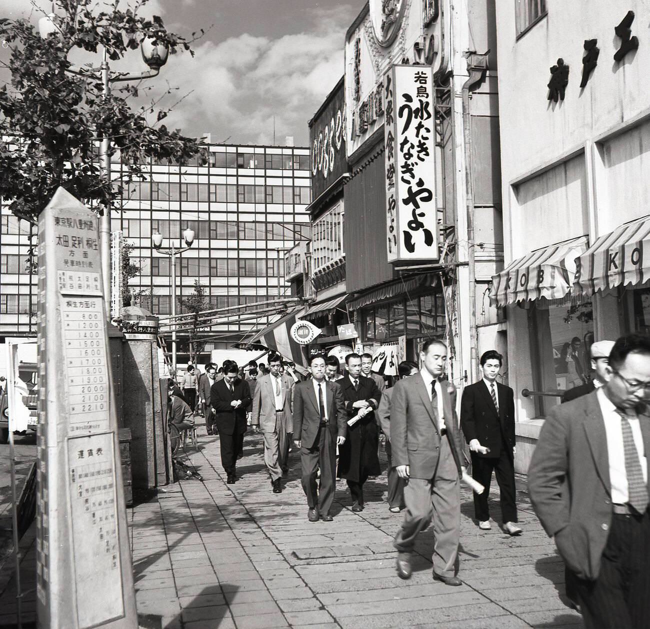 #77 Suited Japanese men walking on a wide pavement on their way to their workplace, 1950s.