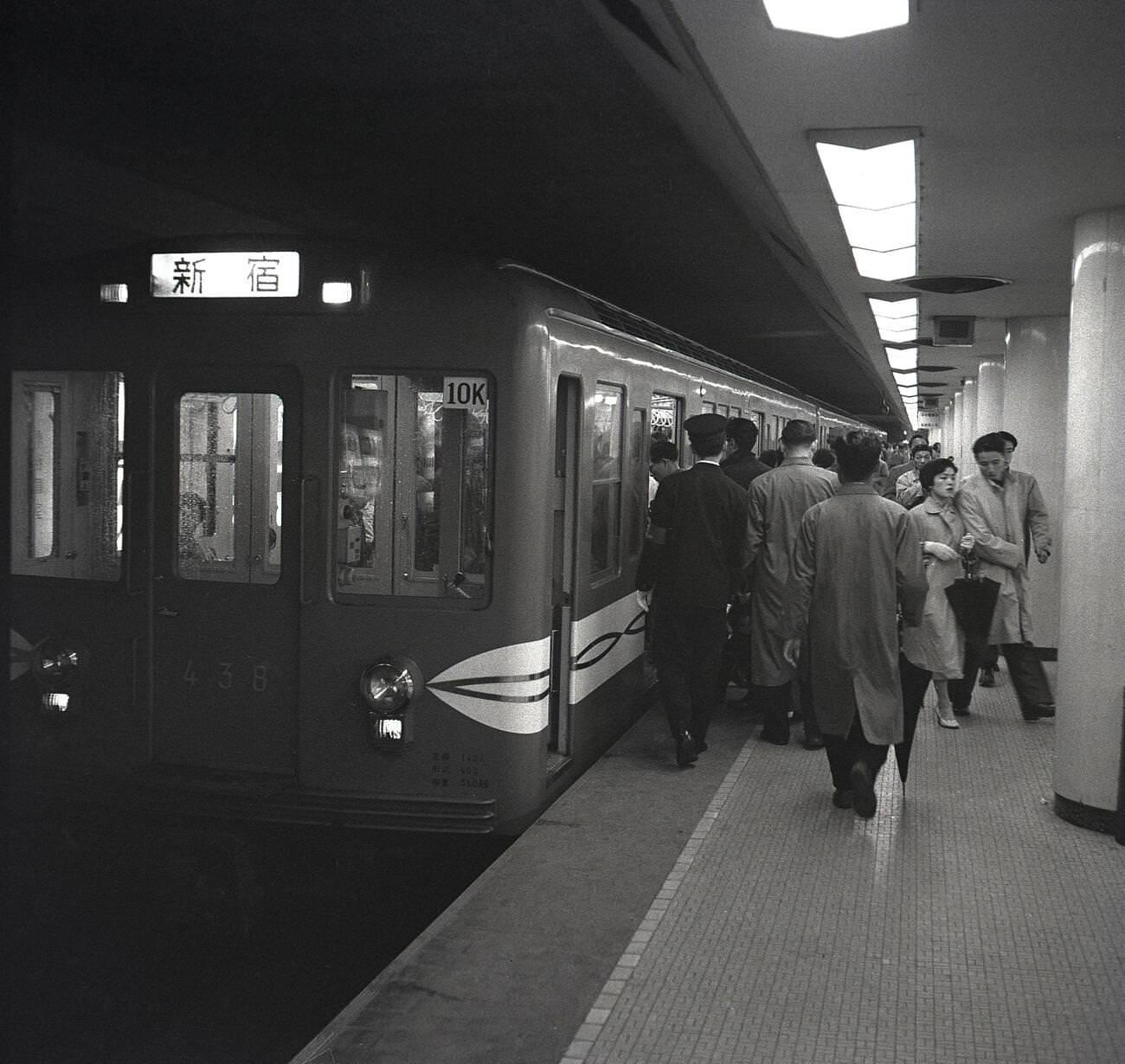 #79 Japanese commuters boarding a metro train in Tokyo, 1950s.