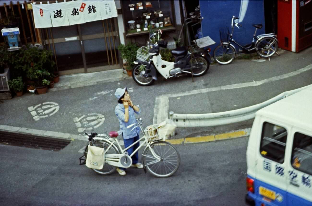 #62 Woman with a bike and shopping on the street, Tokyo, 1970s.