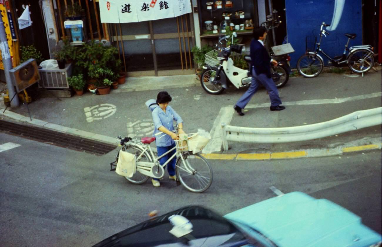 #99 Woman with a bike and shopping on the street, Tokyo, 1970s.