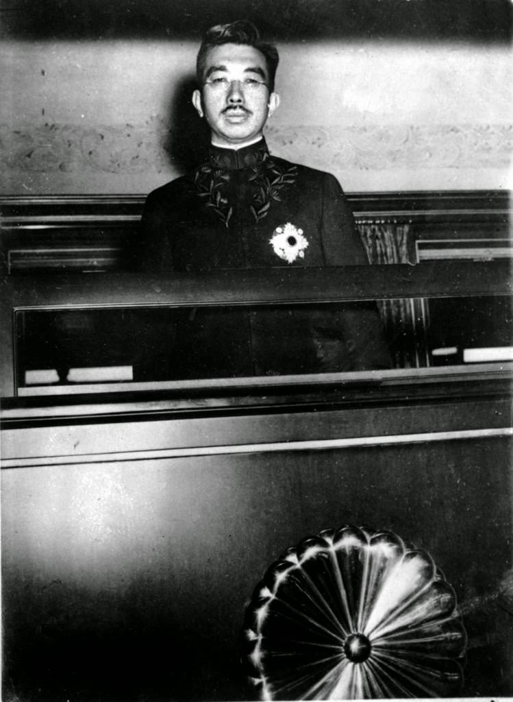 #51 Japanese Emperor Hirohito peers from a window of his special railway car in Tokyo, 1945.