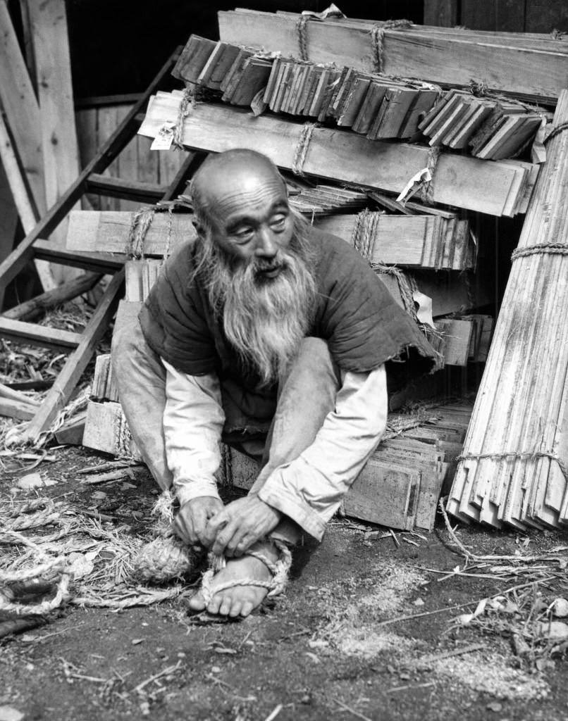#53 Hikosaku Sakamoto, a 63-year-old Japanese farmer, who doubles as a long distance runner and weight-lifter once each year to advertise the shrine festival in his hometown, Shirakawa, Japan, removes his straw sandals after running 125 miles from Shirakawa to Tokyo, 1946.
