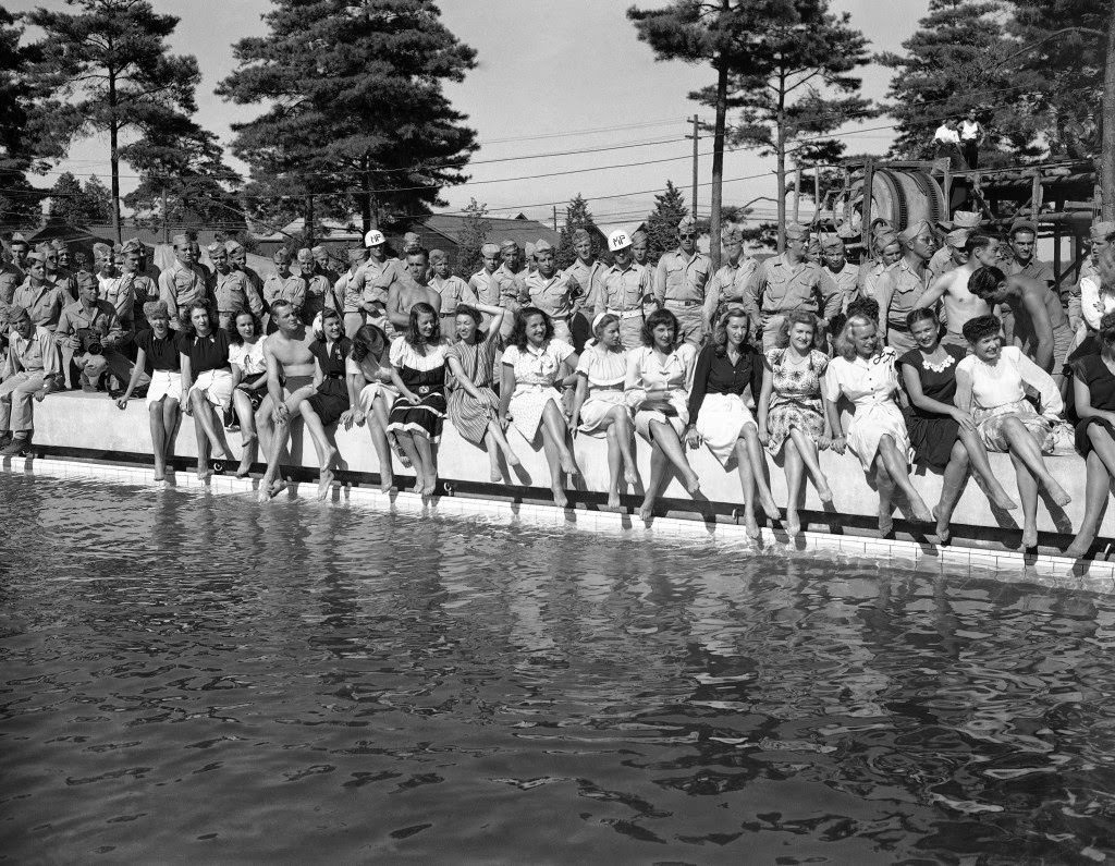 #58 Show girls from the Mikado theater in Tokyo pose on the side of a swimming pool at a new American air base at Yokota, Japan, 1946.