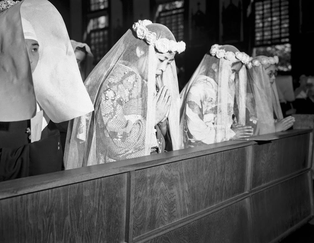 #71 The girls offer up prayers a few minutes before they took their first vow in their first step towards sisterhood, at the altar in Tokyo, 1946.