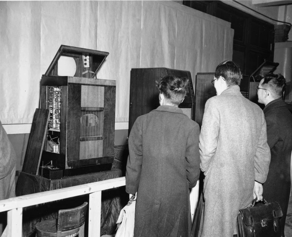 #83 Visitors to the television demonstration at the studios of the Japanese Broadcasting Company wait for the show to appear on the screen of one on the receivers, in Tokyo, 1949.