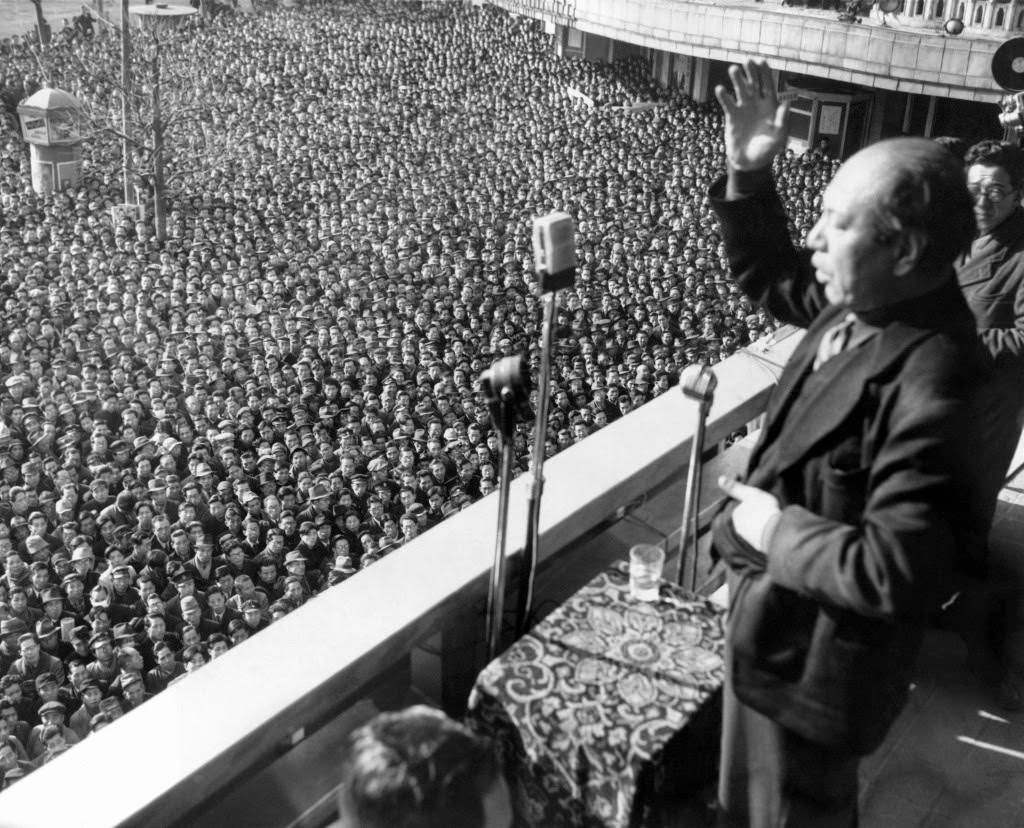 #85 Kyuichi Tokuda, Secretary General of the Communist Party in Tokyo, gestures as he thanks the huge crowd which gathered outside the Asahi newspaper office in Tokyo, 1949.