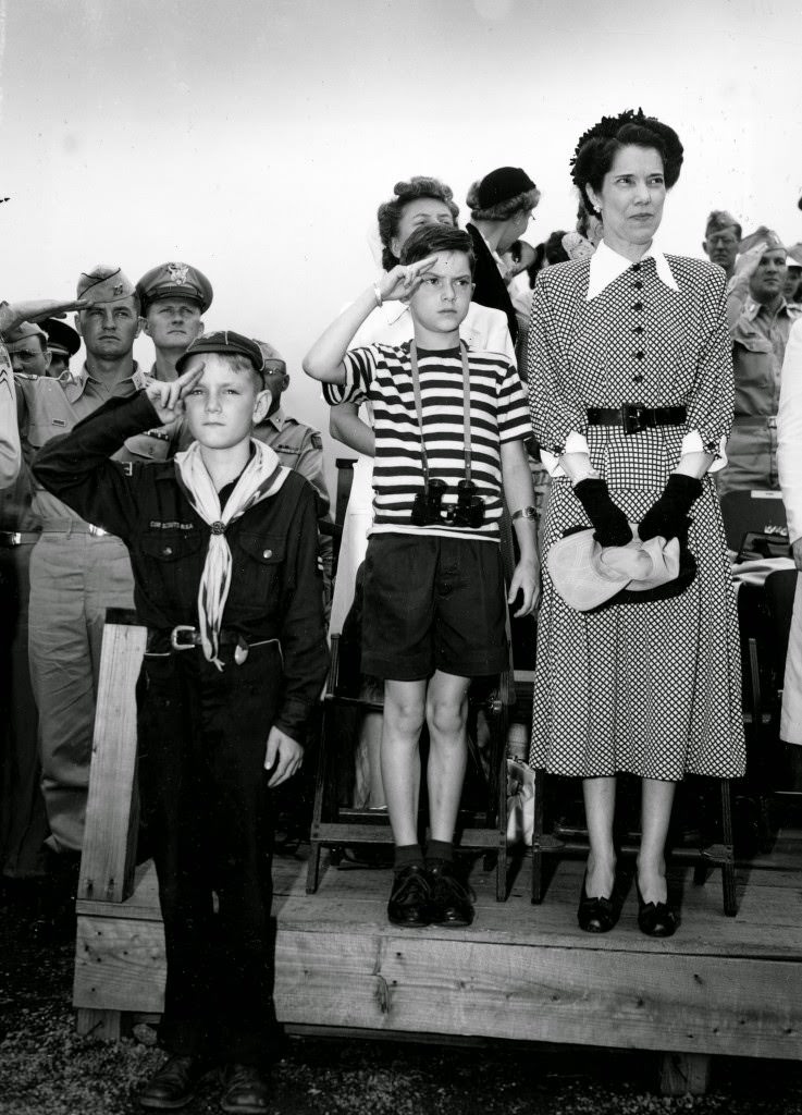 #89 Arthur MacArthur, son of Allied Supreme Commander in Japan, General Douglas MacArthur, salutes a military parade past the Imperial Palace Plaza in Tokyo, 1948.