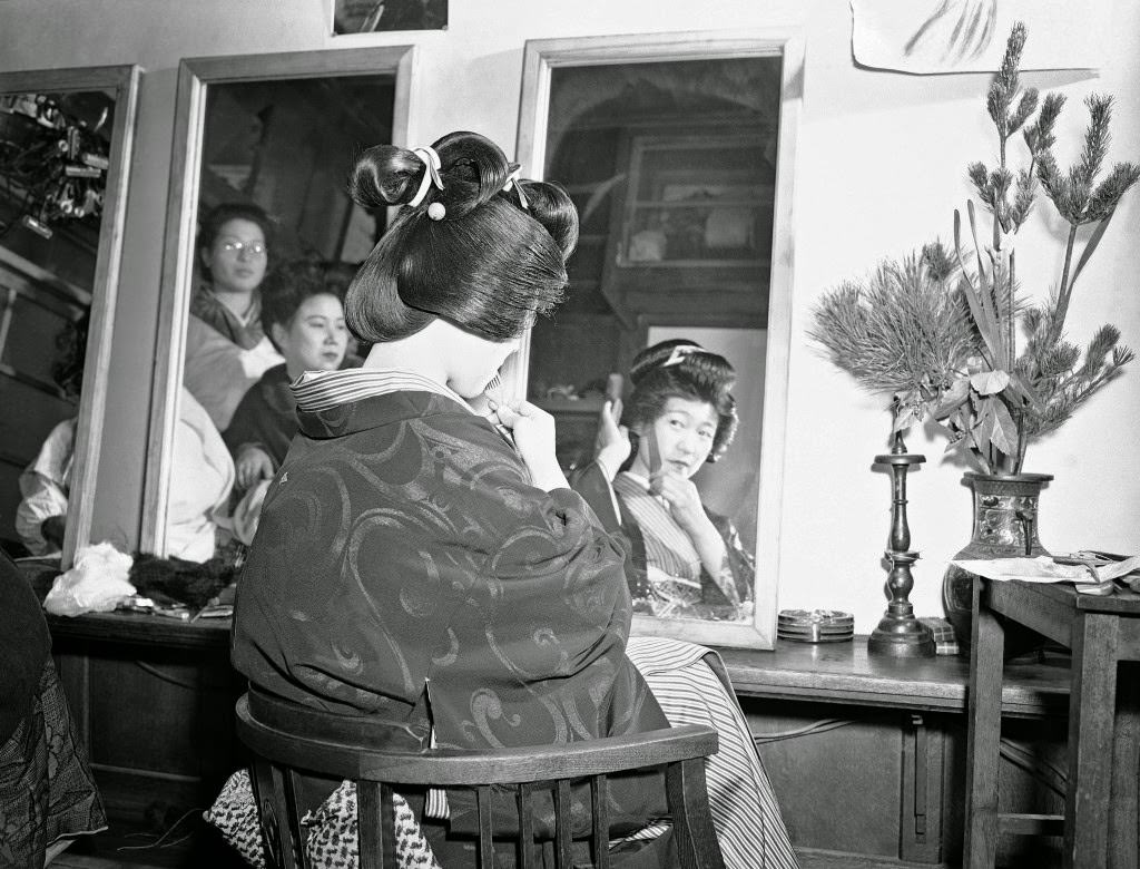 #93 During the first weeks of the New Year, Japanese girls flock to the beauty parlors to have their hair made up in traditional Japanese style. One hopeful getting her hair done shows her coiffure almost finished at the shop on the Ginza in Tokyo, 1948.