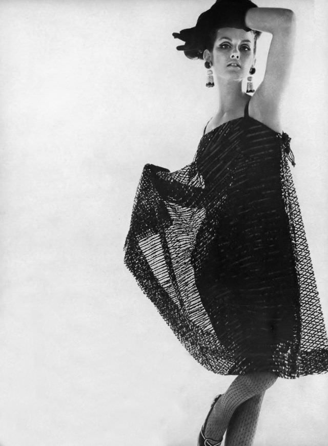 #8 Veronica Hamel in a black cage dress of lace covered with sequins, 1964.