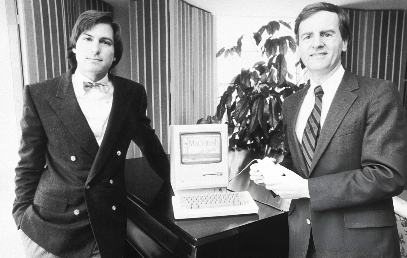 #28 Steve Jobs and John Sculley pose with the new Macintosh personal computer, 1984