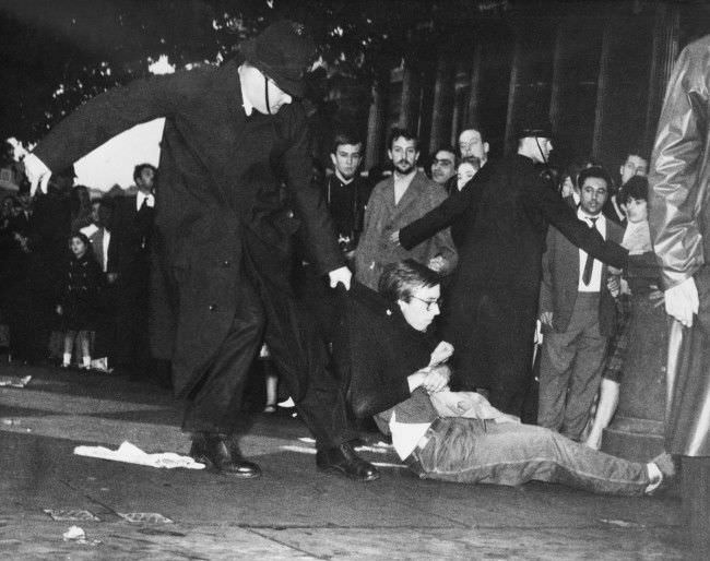 #17 A young man in beatnik-style clothes is dragged along by a policeman, 1961.