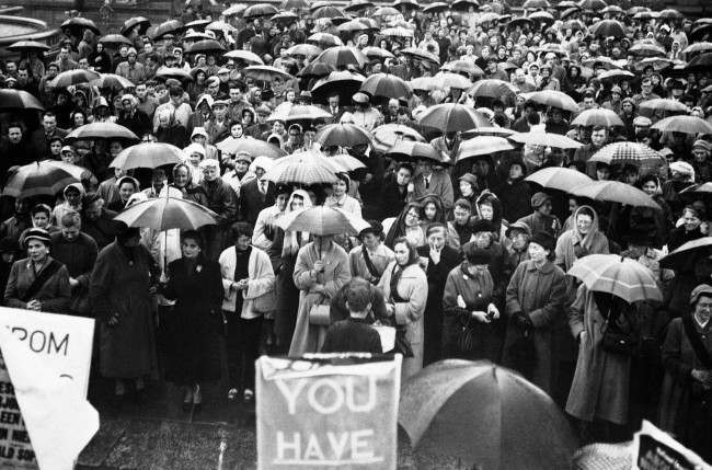 #2 A huge crowd of mostly women sheltered under their umbrellas in Trafalgar Square, London, at a mass meeting of the National Council for the Abolition of Nuclear Weapon Tests, 1957.