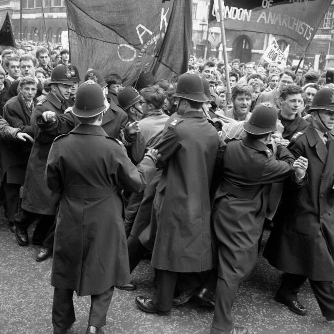 #29 Police straining against a solid mass of people in an effort to control a contingent of Aldermaston to London marchers as they made their way to the final rally in Hyde Park, 1963.