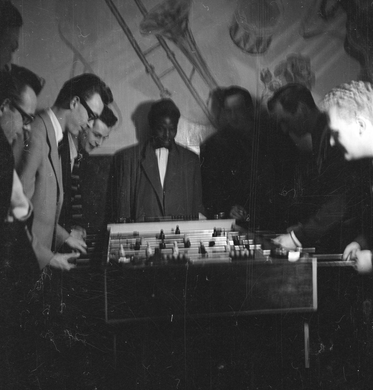 #11 A man at a bar by Nigel Henderson c.1954Photograph of jazz musicians playing table football, including Tony Crombie and Derek Humble Nigel Henderson 1917-1985