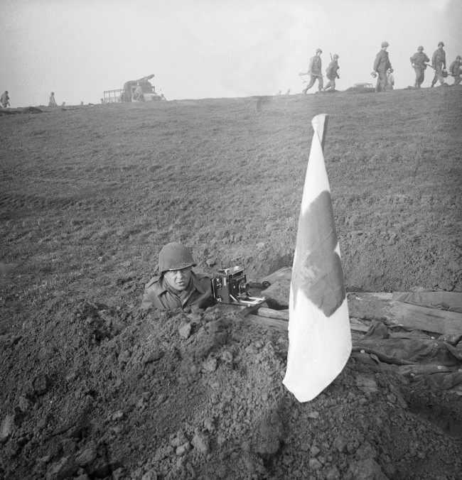 #24 Henry Griffin, Associated Press war photographer takes cover in a fox hole on the banks of the Rhine. 1945