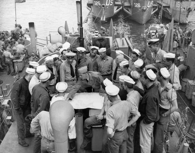 #16 Lt. William V. Patten briefs his crew at a port in England before the invasion of France began, 1944.