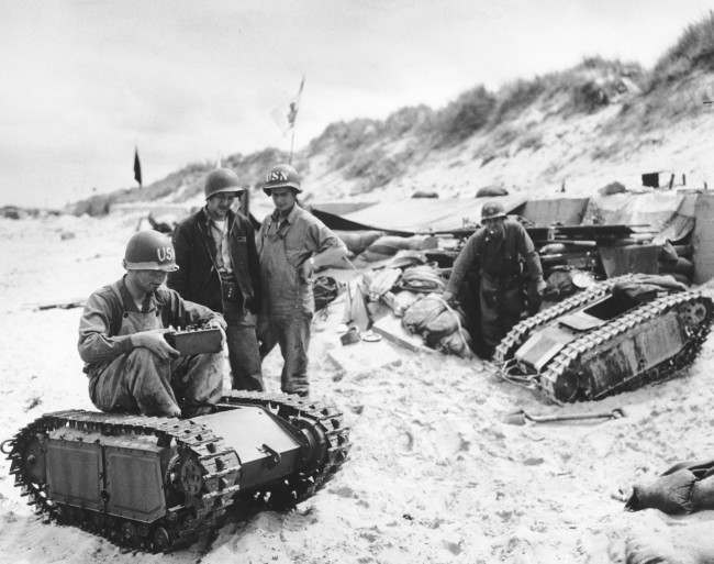 #20 U.S. Navy men take apart a German “Beetle”, a miniature tank loaded with explosives, during the Allied Normandy landings in France, 1944.