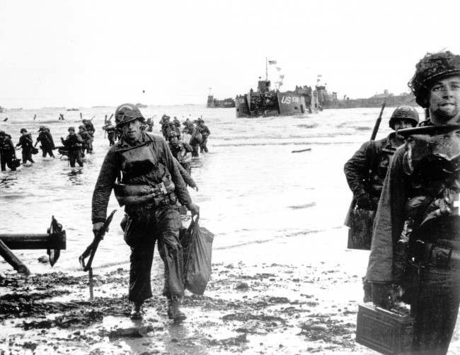 #26 Carrying full equipment, American assault troops move onto a beachhead code-named Omaha Beach, 1944.