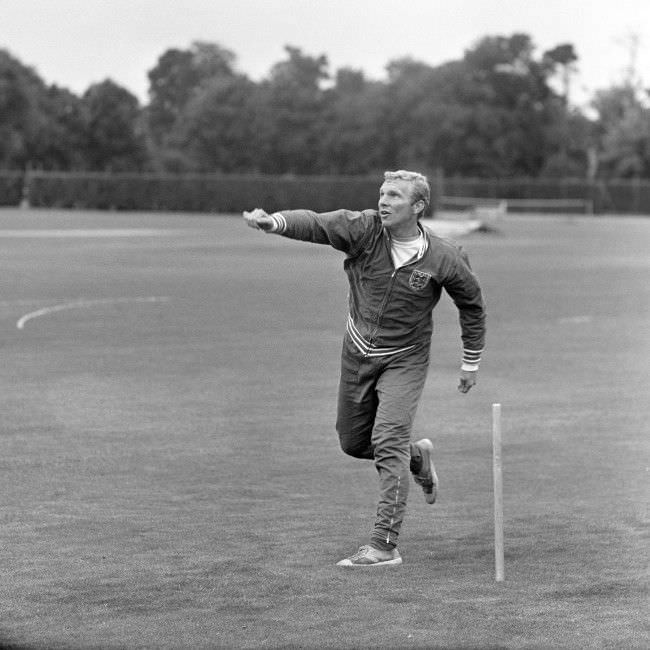 #8 England captain Bobby Moore turns his arm over as the players relax with a game of cricket, 1966.