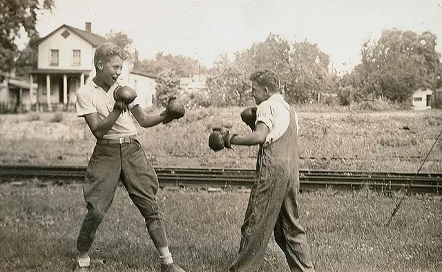 #15 Young men boxing by the railroad tracks.