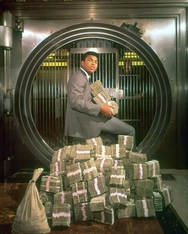 #14 Muhammad Ali with his all of his ‘Ginormous’ winnings, 1974.