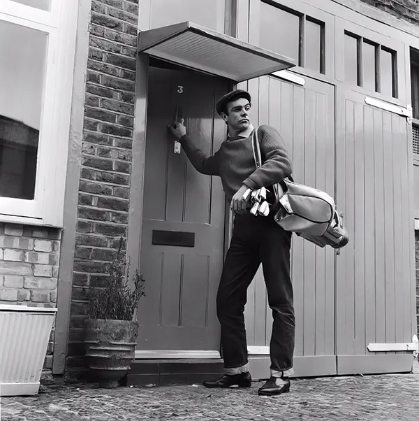 #16 Sean Connery leaves his basement flat in London for a game of golf, 1962.