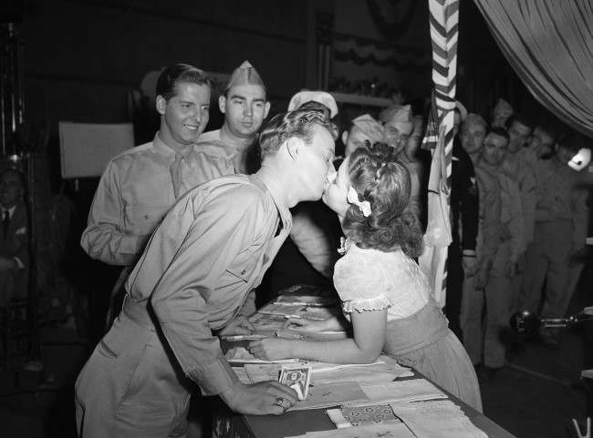 #24 For the first time in her long movie career, Shirley Temple gets kissed in grown-up fashion by Jerry Shane, an ex-Marine from Grand Rapids, Mich., who plays a bit part in the movie called “Kiss and Tell,” Jan. 19, 1945.