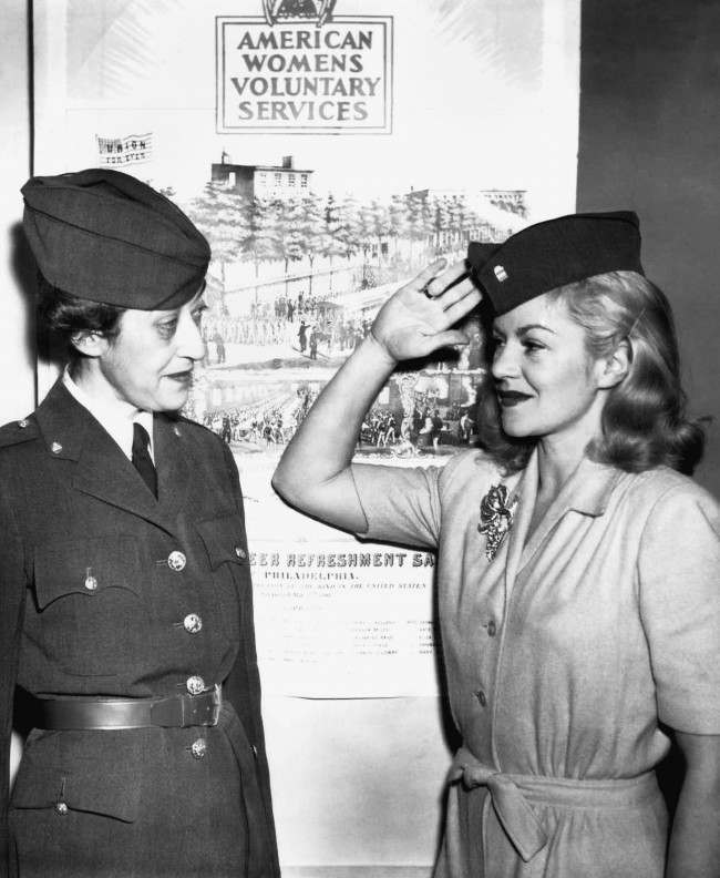 #26 Mrs. Morton S. Stern (left) gets a salute from Claire Trevor after the movie actress had been inducted in the American womenÂs voluntary service in New York, Dec. 18, 1941.