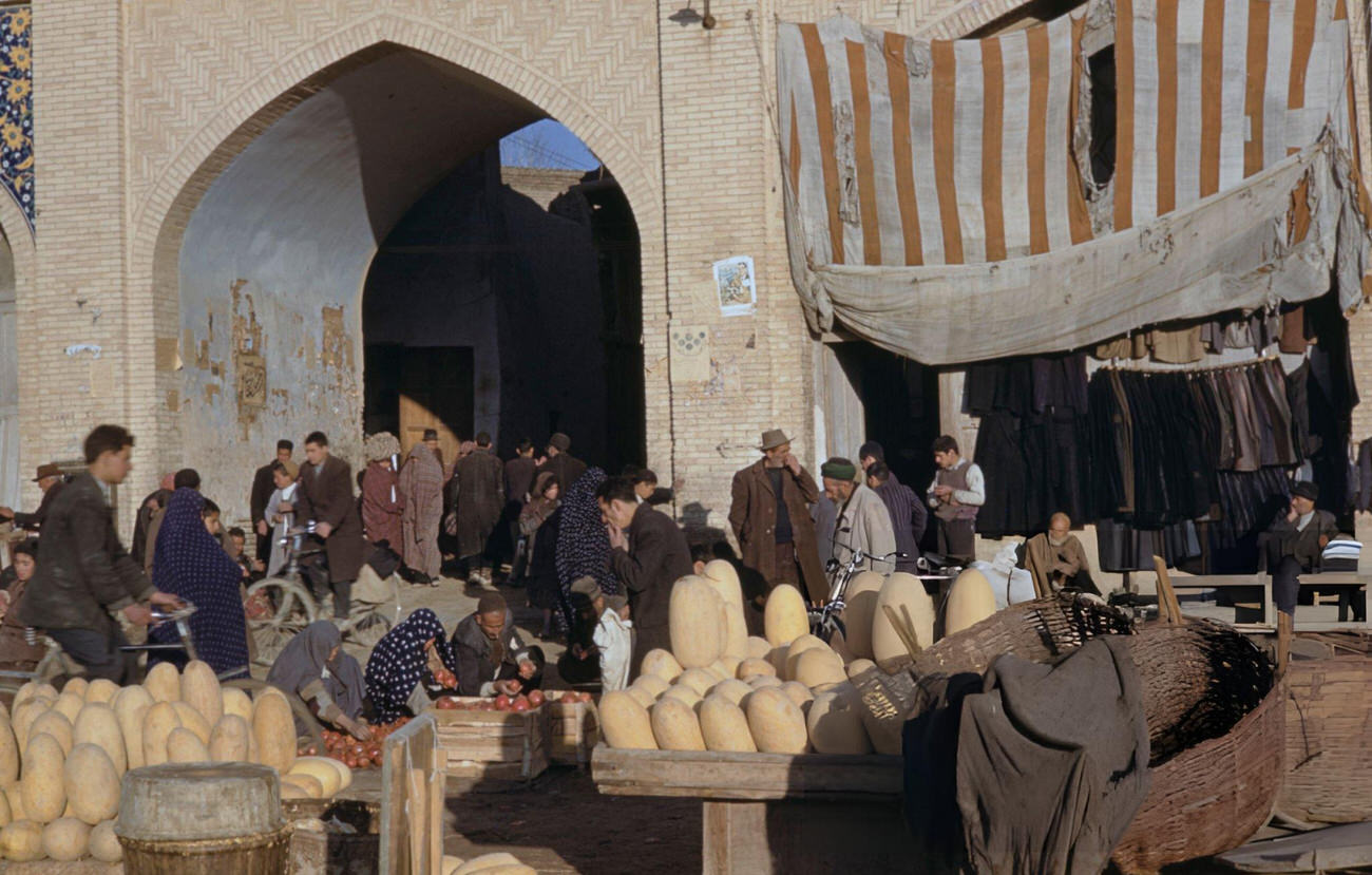 #47 Pedestrians passing customers being served by market traders on a street in the bazaar district of Isfahan, in the Isfahan Province of Iran, circa 1960.