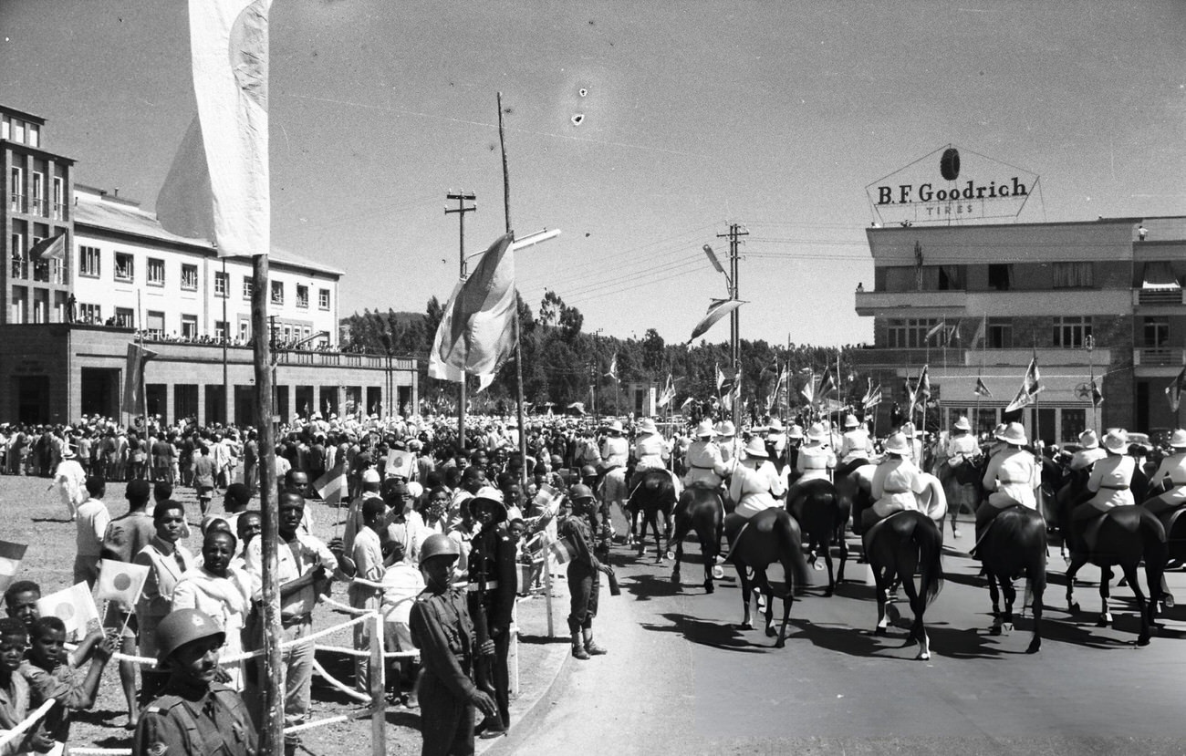 #52 Horseback soldiers leading cars carrying Crown Prince Akihito and Crown Princess Michiko under an arch where a drawing of Crown Princess Michiko is hung on the way to the Guenete Leul Palace, Addis Abeba, 1960.