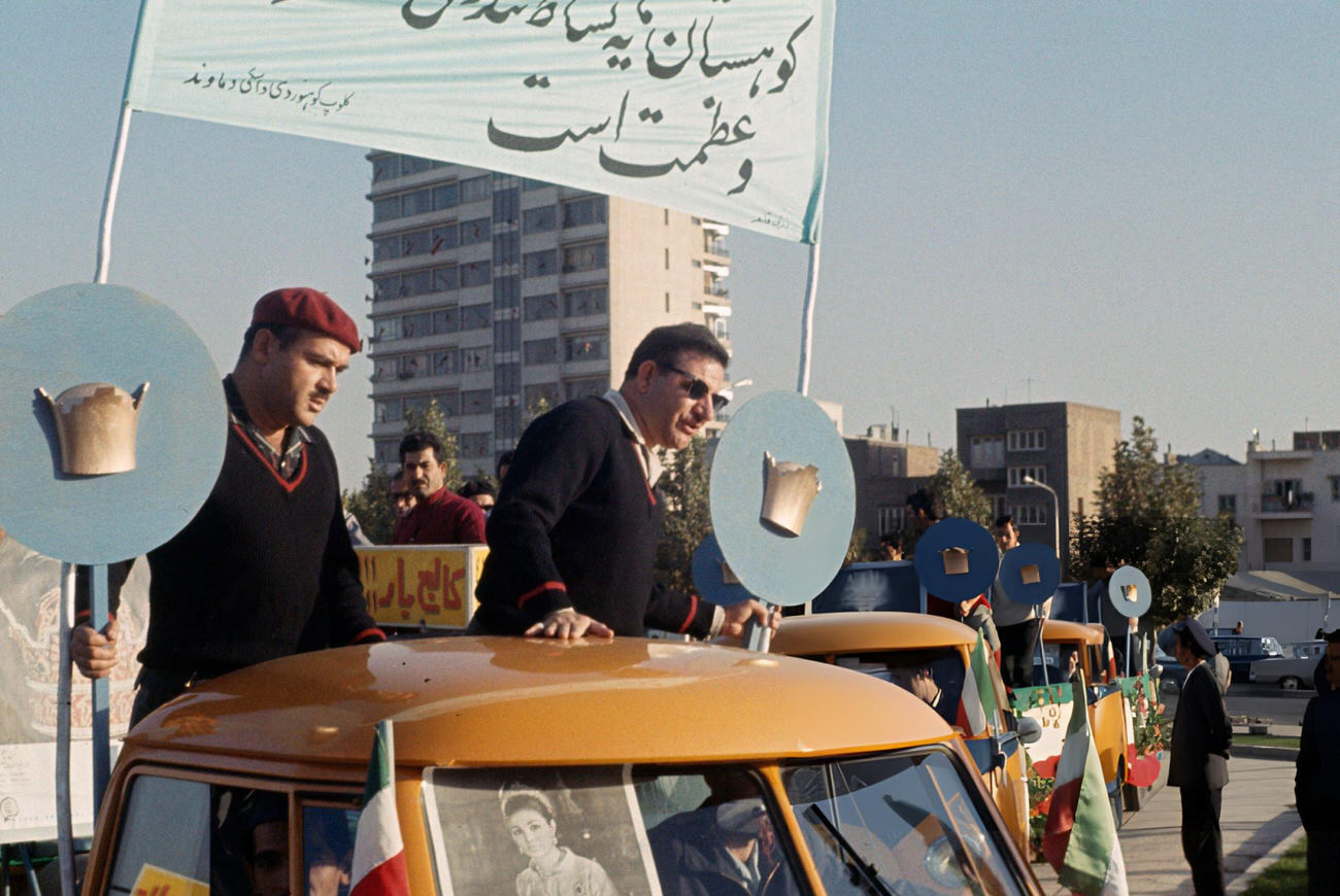 #64 Cars decorated with flags and crowns in preparation for the coronation of Shah Mohammed Reza Pahlavi, Tehran, Iran, 1967.