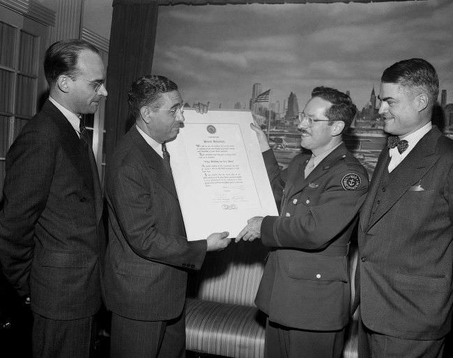 #11 Joe Rosenthal, Associated Press staff photographer, receives a scroll from Joe Costa on behalf of the Press Photographers Association of New York in a ceremony commending him for his photo of the flag raising on Iwo Jima, in New York, 1945.
