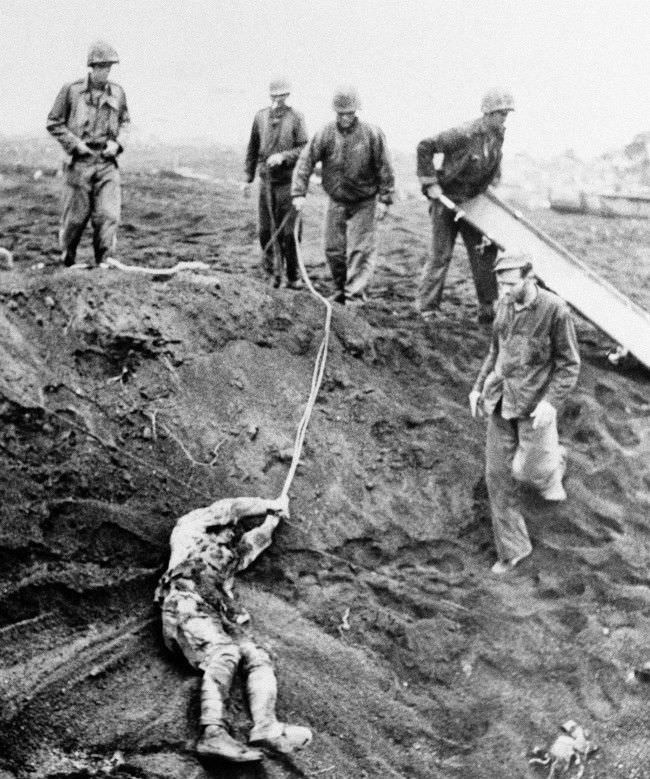 #17 The first Japanese prisoner to be taken on Iwo Jima, Japan, is dragged from shell hole, 1945.