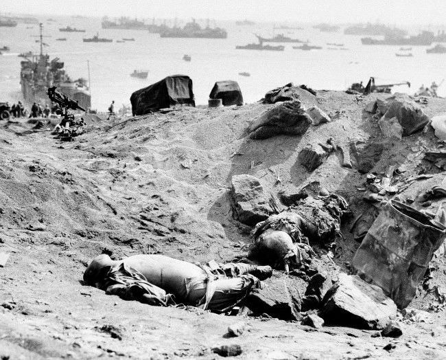 #24 Two Japanese soldiers lay dead from the invasion armada seen in the background in Japan, 1945.