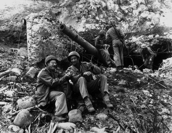 #4 Joe Rosenthal, AP photographer, with Bob Campbell, a Marine, in front of a large Japanese gun, 1945.