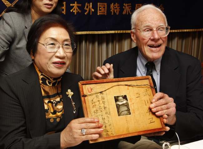 #50 Former U.S. soldier fighting on Iwo Jima during the World War II, Franklin Hobbs, right, and Chie Takekawa, whose father was killed in the same battle, hold a framed letter and a photo of her sister during a press conference at the Foreign Correspondents Club of Japan in Tokyo, 2010.