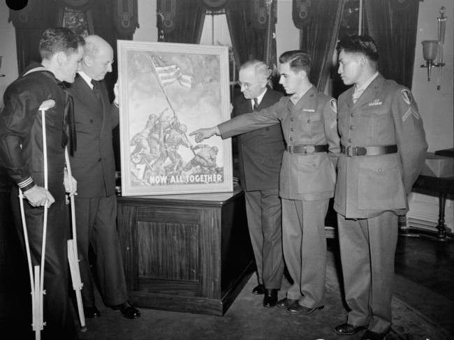#8 With the three survivors of the famed Mt. Suribachi flag-raising incident as his guests, President Truman gets the first of the new 7th war loan posters, based on Joe Rosenthal’s epic Iwo Jima photograph, at the White House, 1945.