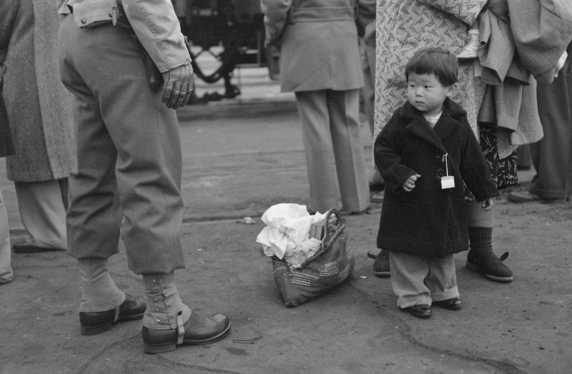 #12 Japanese-American child being evacuated with his parents to Owens Valley, 1942.