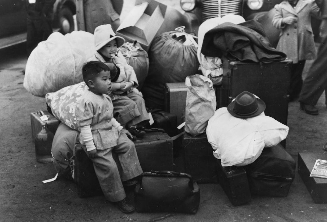 #16 Japanese-Americans waiting for a train to take them and their parents to Owens Valley, 1942.