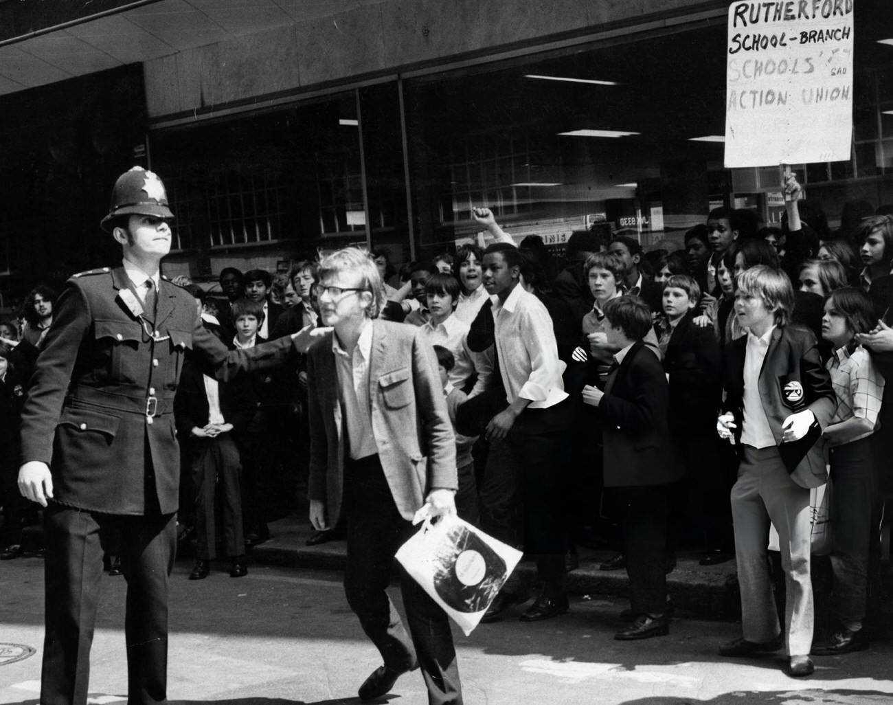 #6 Leader of school strike Steve Finch, aged eighteen, with fellow pupils of Rutherford School, is escorted by a policeman to a meeting in London, 1972.