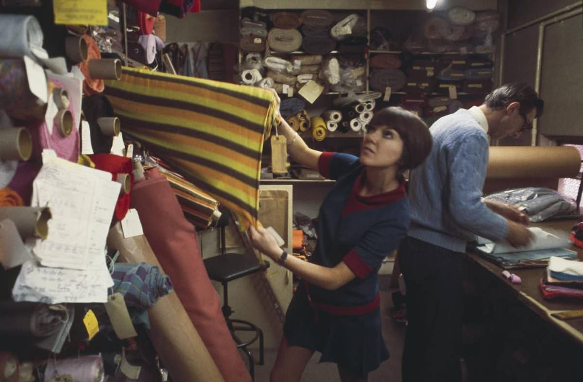 #12 Mary Quant selects rolls of fabric from a warehouse store in London to create samples for a future collection in 1967