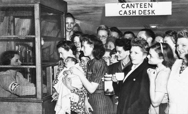 #27 Deep in tubes underneath underground railway lines in London shelters provide safety from buzz bombs, July 25, 1944. They crowd around the canteen cash desk to get receipts for money spent in the canteen on refreshments