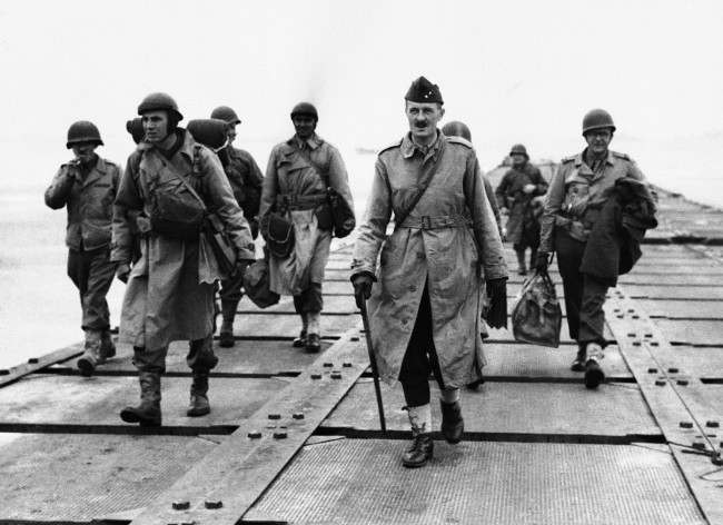 #20 French General Philippe Le Clerc, carrying walking stick, shown walking down a pier somewhere in Normandy, France, 1944, after his arrival. This is his first visit to France in four years.