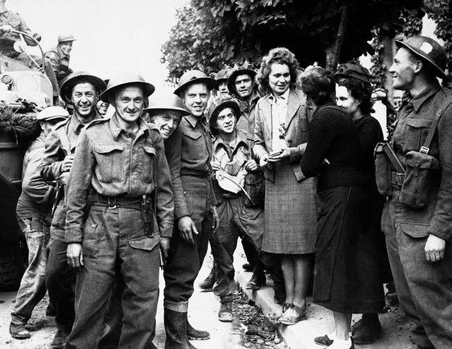 #23 French girls give a hearty welcome to Canadian troops passing through a town in the Normandy coast area of France, 1944.