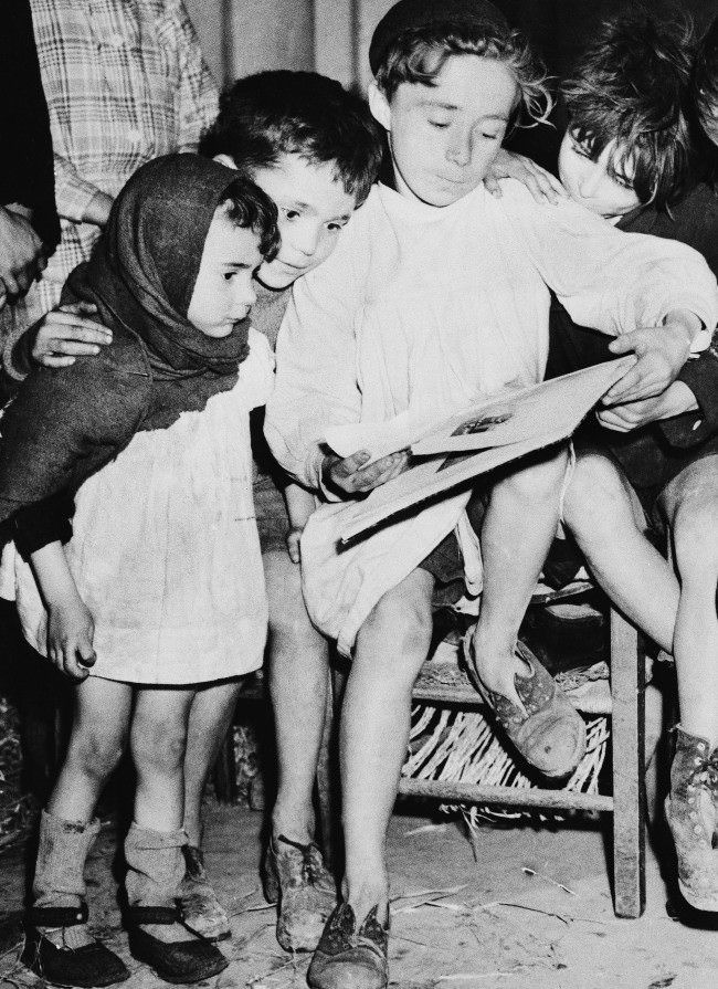 #25 While the battle raged around them during the allied push in Normandy last summer, these French children found refuge in the Cathedral in Caen. Most of them were stocking less, their shoes were torn, their garments shoddy, 1945.