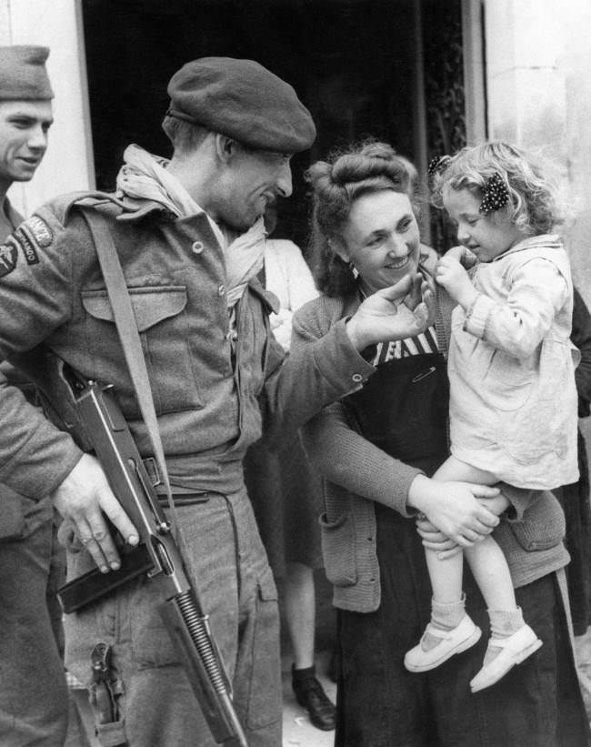 #30 French villagers welcomed members of a French Commando who landed in Normandy in Amfreville, North of Ranville, 1944. Chester Wilmot, BBC commentator was also there at the time.